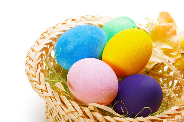 istock Colorful Easter eggs in a wicker basket surrounded by decorative flowers 2246648392