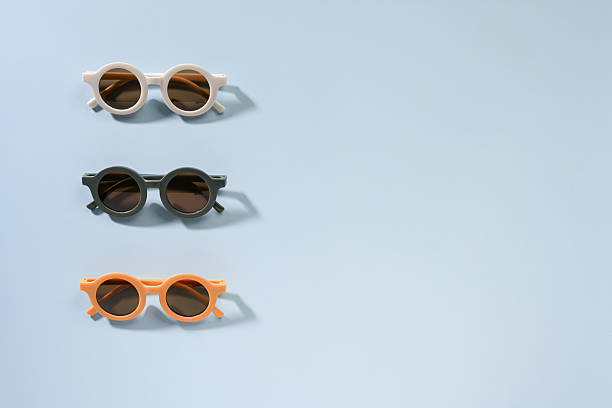 istock Sunglasses in different colors on blue background 2246649141