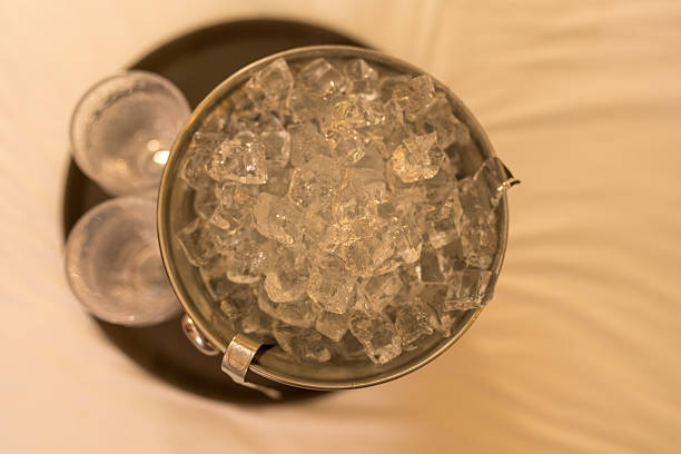 Top view of a bucket filled with ice placed on a white bed in a luxury hotel