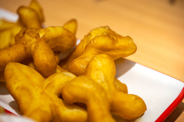 Golden Fried Dough Twists Served on a White Plate with Red Trim