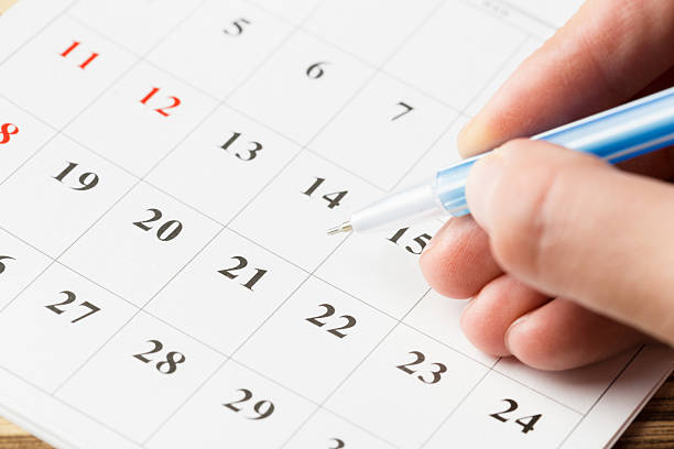 istock Person writing on a calendar to plan events and organize schedule in October 2246651046