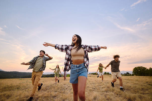 istock Cheerful friends having fun while running in nature at sunset. 2246651583