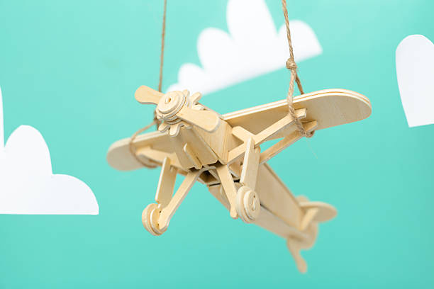 Asian three-year-old child playing with airplane model on the grassland