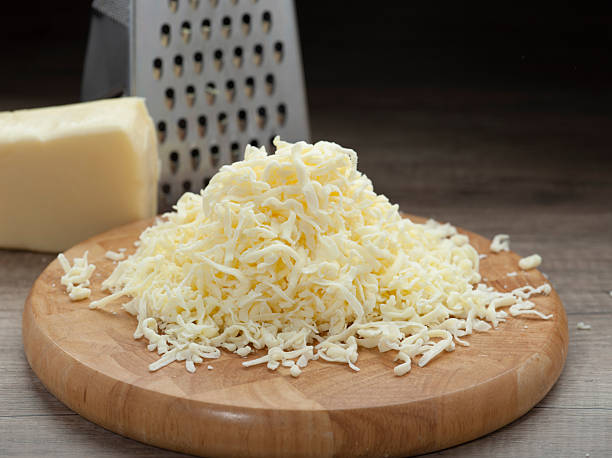 istock Shredded Mozzarella Cheese with Block and Grater on Wooden Surface 2246652045
