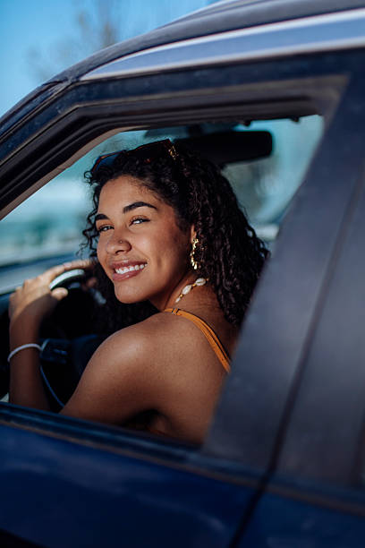 istock Smiling young woman driving on a sunny day 2246652327