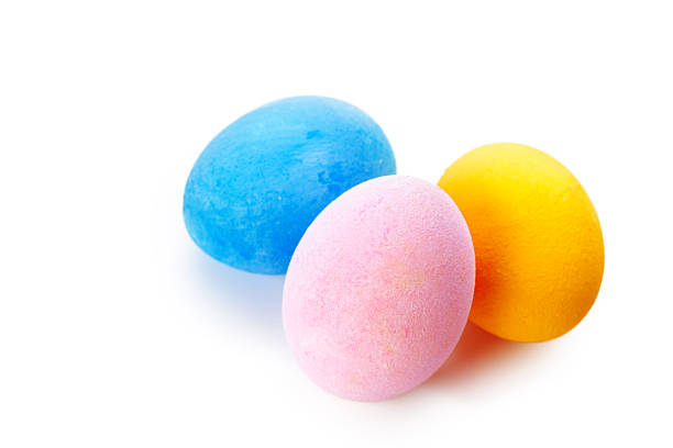 Vibrant pastel eggs are arranged together, showcasing blue, pink, and yellow hues for Easter.