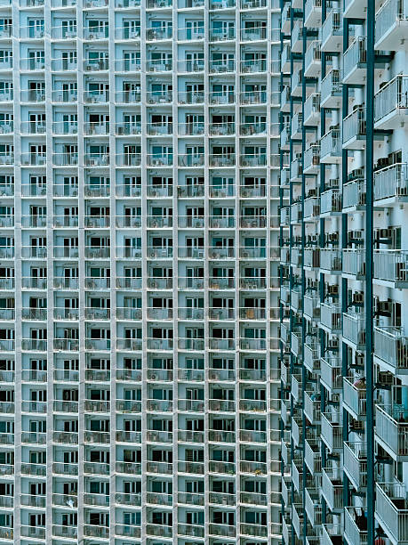 A compelling close-up of a modern, high-rise apartment building facade in Makati City, Metro Manila, Philippines. The photograph emphasizes the highly repetitive, geometric grid created by the endless array of balconies and windows. This abstract, rhythmic pattern is excellent for graphic design backgrounds, architectural studies, articles on density, urban planning, or illustrating themes of uniformity, scale, and housing in a fast-growing Asian metropolis. The neutral colors offer a versatile look for various creative projects.