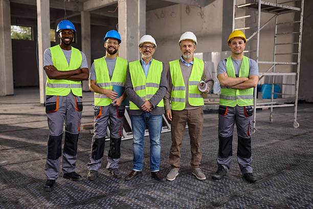 istock Happy civil engineers with manual workers at construction site. 2246653311