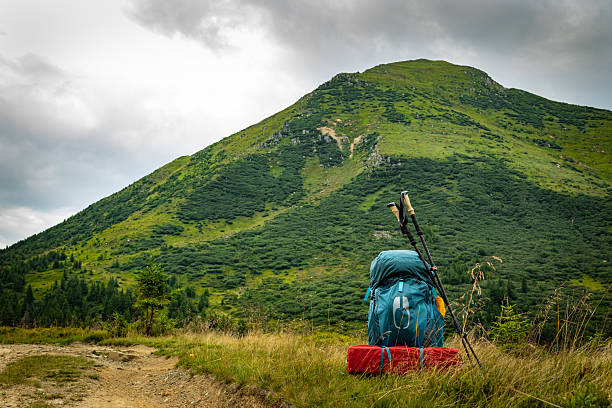 Summer hiking in the mountains with a backpack and a tent. Beautiful mountain landscape.