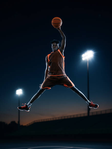 Creative graphic artwork. Confident basketball player celebrating mid-air dunk under arena lights