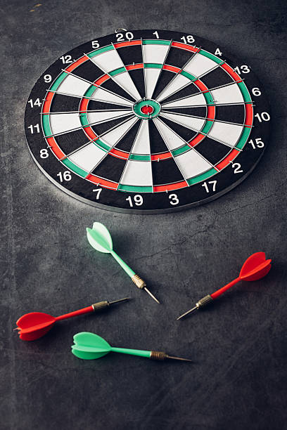 istock Colorful Darts and Traditional Dartboard on Dark Surface 2246657409