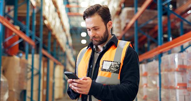 istock Man, phone and worker in warehouse for shipping, distribution schedule or inventory management. Mobile, logistics and person with app to check stock, online communication and email for supply chain 2246657450