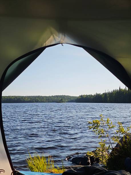 istock view from inside a tent showing a tranquil lake and mountains, with a person's legs visible 2246657881