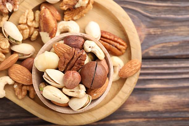 istock Mix of different nuts on wooden table, top view. Space for text 2246659371