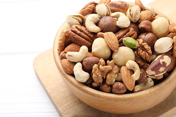 istock Mix of different nuts in bowl on white table, closeup. Space for text 2246659424