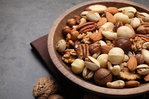 istock Mix of different nuts in bowl on grey table, closeup. Space for text 2246659447