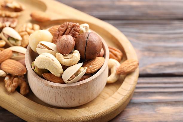 istock Mix of different nuts on wooden table, closeup 2246659453