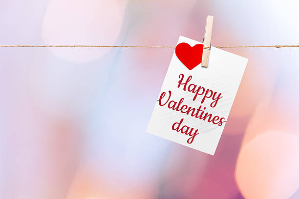 istock Happy Valentines Day greeting card hanging on a string with a heart shape 2246659828