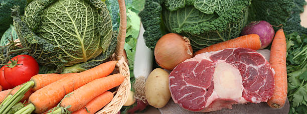 Pot-au-feu being prepared. Beef with marrow bones. Shank. Mixed raw vegetables: green cabbage, carrots, turnip, potato, onion, leek. Traditional French cuisine.