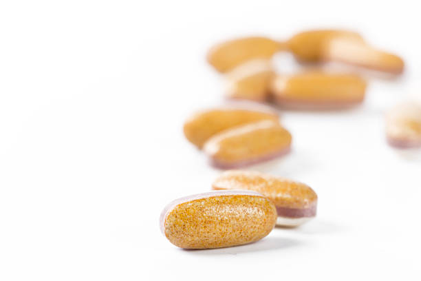 istock Health supplements scattered on a white surface with focus on one capsule 2246662902