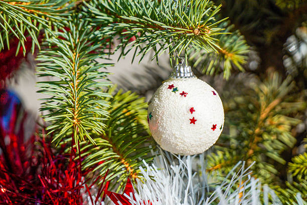 istock Christmas tree ornament with star pattern hanging on a festive evergreen branch 2246663508
