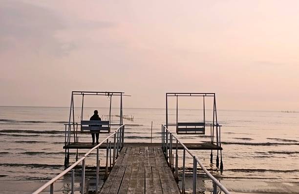 San Feliciano, Lake Trasimeno, Perugia, Umbria, Italy: Silhouette of woman in contemplation on the sunset of San Feliciano