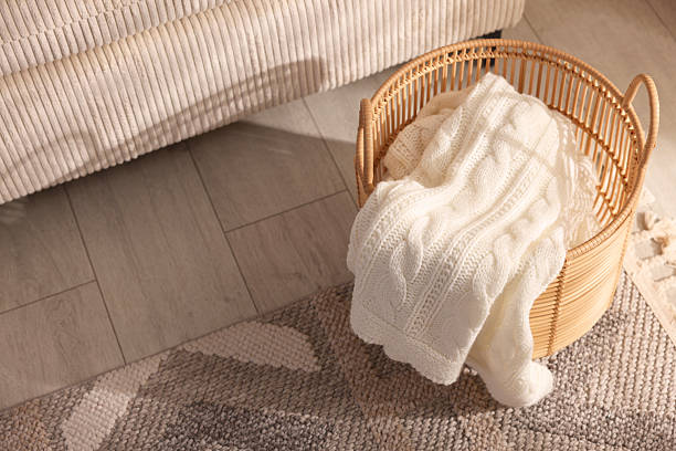 istock Wicker basket with knitted blanket on floor indoors 2246665402