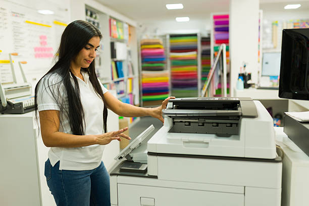istock Woman printing documents at copy and print shop 2246669456