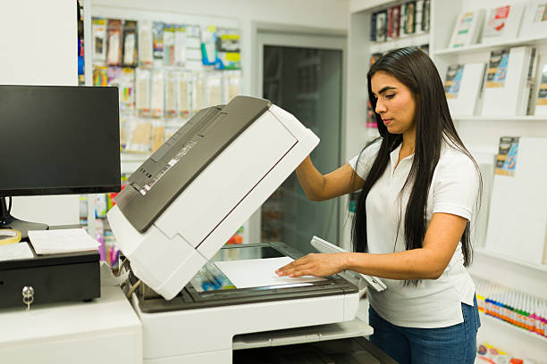 istock Woman making copies at print shop service 2246669486