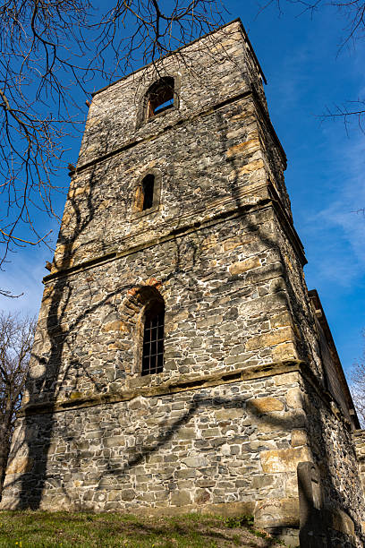 istock A half-demolished stone church behind the enclosure wall with blue sky. 2246669907