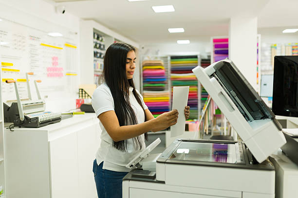 istock Woman making copies in cheerful print shop 2246670133