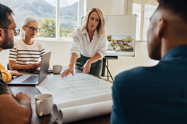istock Team discussion in a modern architecture firm with professionals in an office 2246670417