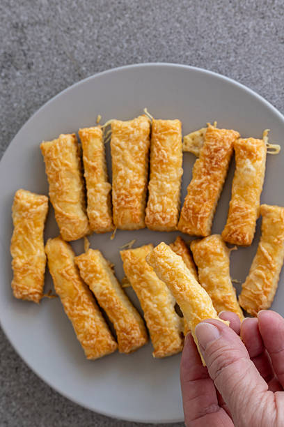 istock hand holding a homemade cheese stick 2246670421