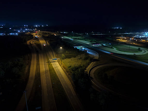 istock Traffic flows along the brightly lit highway interchange at night 2246670962