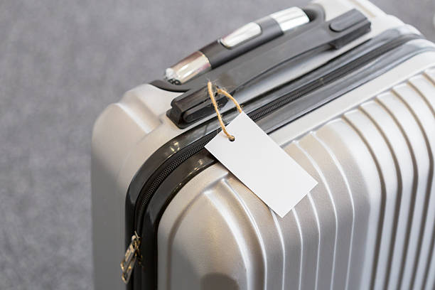 istock Silver suitcase with a blank tag resting at an airport terminal 2246672238