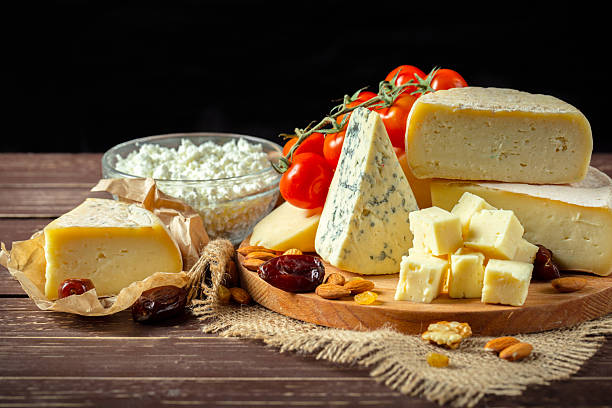 istock Cheese platter with assorted cheeses, fresh tomatoes, and nuts on wooden table 2246672778