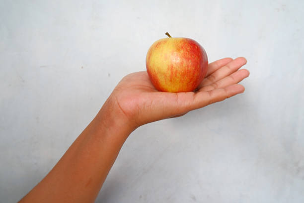 Hand Holding Fresh Apple  Healthy Food Concept on Light Background