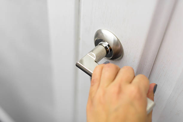 istock Hand turning a modern door handle in a bright, minimal hallway 2246674873