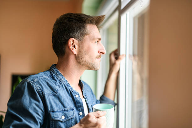 istock Happy relaxed man enjoying quiet time with coffee close to a window 2246677131