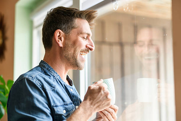 istock Happy relaxed man enjoying quiet time with coffee close to a window 2246677145