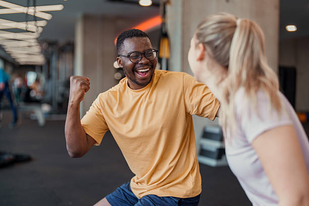 istock Bright indoor gym scene with diverse young adults exercising and sharing joyful interaction 2246679168