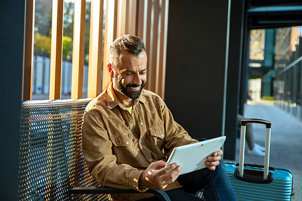 istock Man traveler using digital tablet while waiting for the transport 2246679682