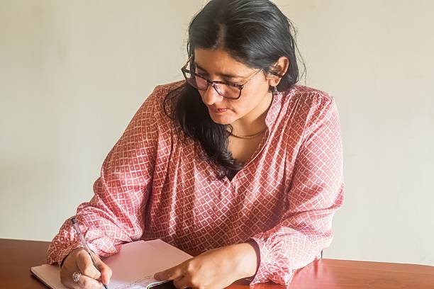 istock A woman is writing in a notebook 2246683289