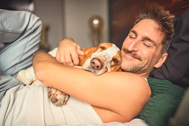 istock man and her Basset dog at home bed 2246686621
