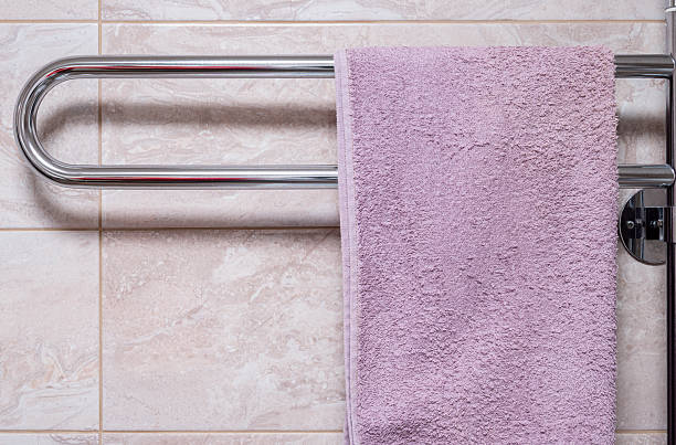 istock A towel hangs on a chrome heated towel rail in a bathroom against a tiled wall. 2246686842