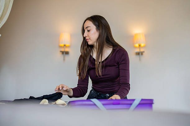 istock Woman packing suitcase in hotel room 2246688542