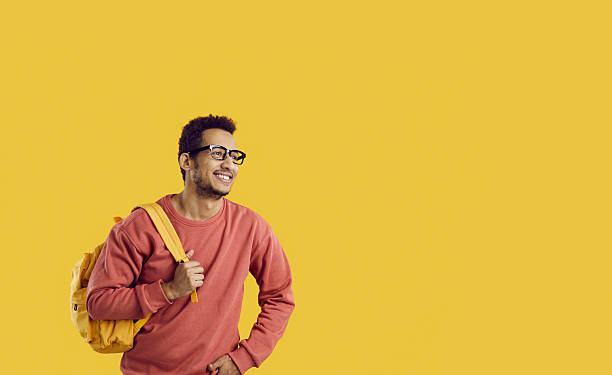 istock Happy black college or university student with backpack on yellow copy space background 2246691373