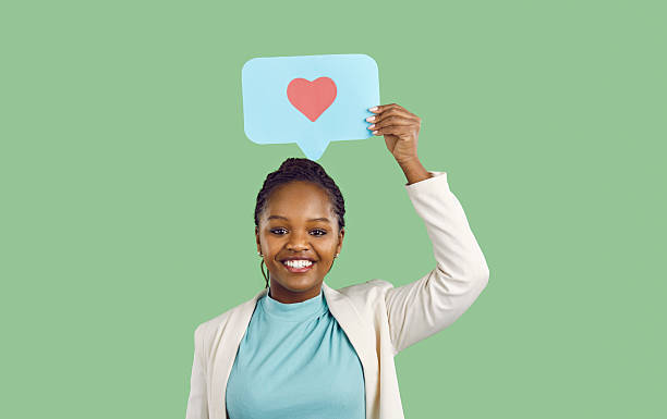 istock Joyful young dark skinned woman holds speech bubbles, leaves comments or likes under post. 2246693116