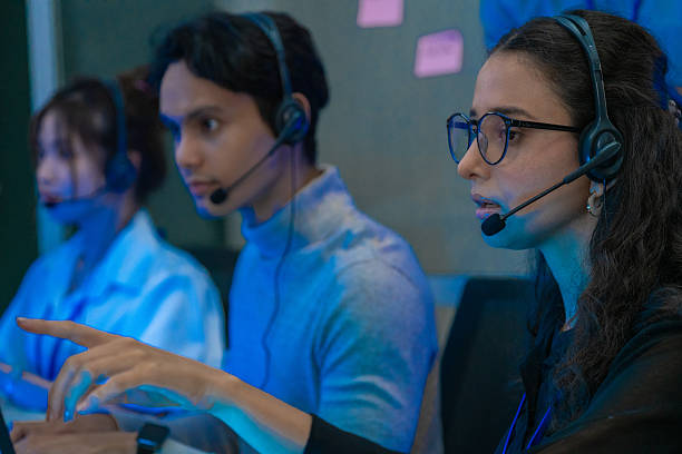 istock Customer support team in a modern call center receiving guidance from a supervisor. Diverse employees working with headsets and computers, representing teamwork, communication, and business technology. 2246694074