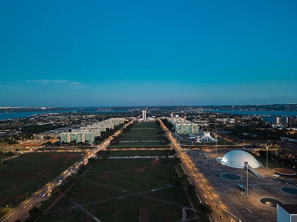 Brasília, February 19, 2025. Early night view featuring the Metropolitan Cathedral, the National Museum, and the lit Ministries Esplanade.